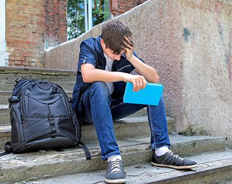 Boy sitting on school steps